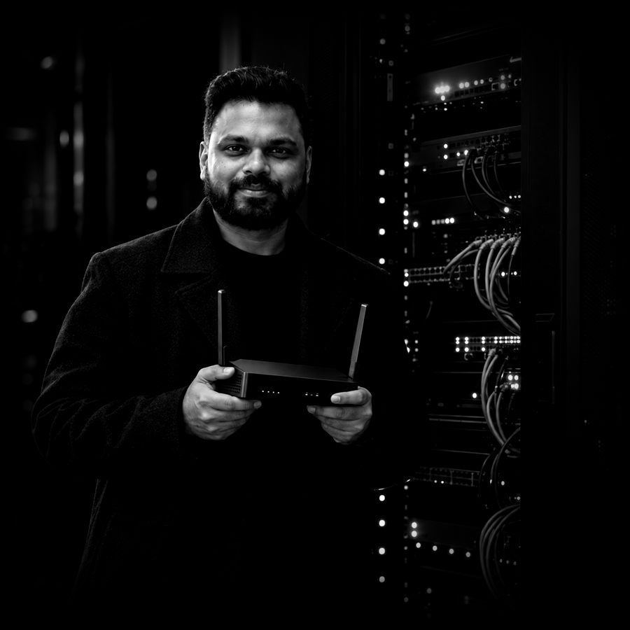 Adharna holding an LTE router in front of a server rack